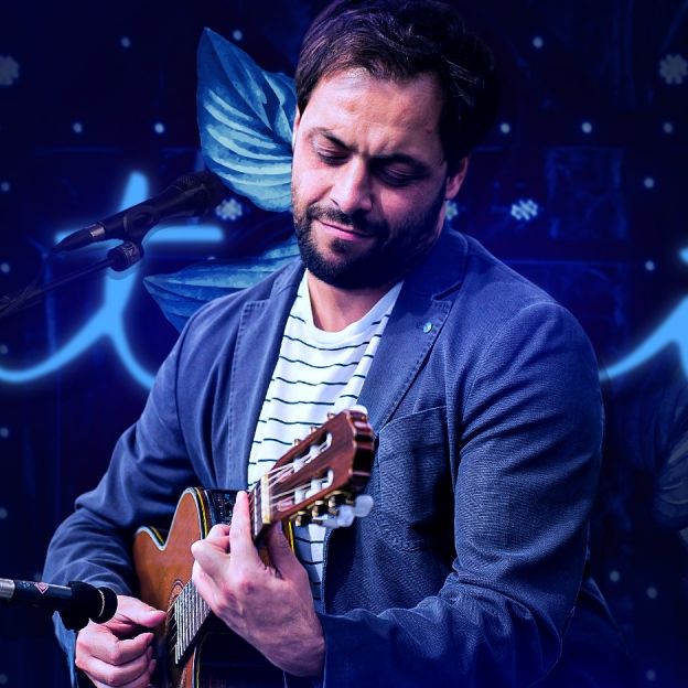 O músico Antonio Zambujo toca violão no centro da imagem