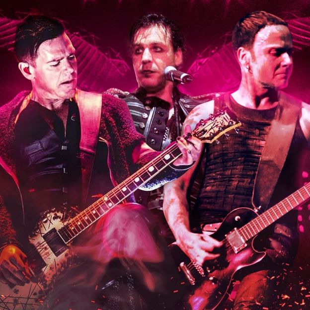 Três integrantes da banda Rammstein se apresentam ao vivo lado a lado no centro da imagem