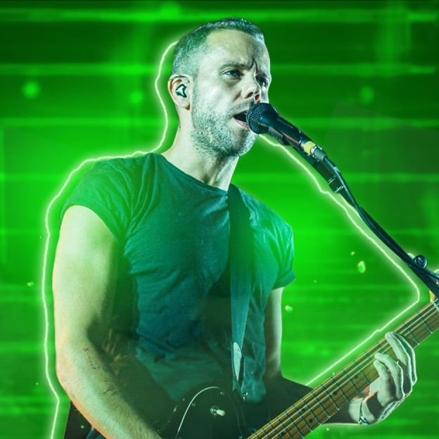 Vocalista do grupo M83 canta e toca guitarra no centro da imagem